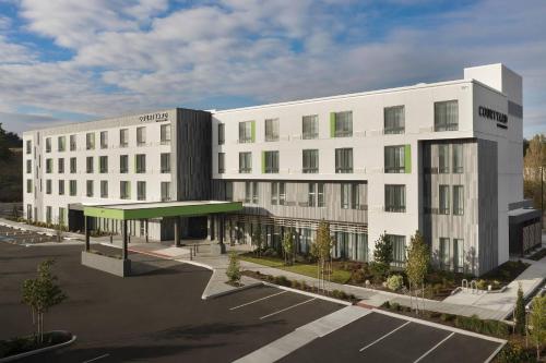 a rendering of a white building with a parking lot at Courtyard Portland East in Portland