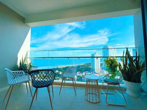 a balcony with chairs and a view of a city at The Song Apartment 5 Stars Vung Tau - Căn Hộ Du Lịch 5 Sao Cạnh Biển - Dumin's Homestay in Vung Tau