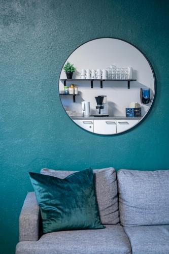 a mirror above a couch in a living room at Hotel Pohjankievari in Kempele