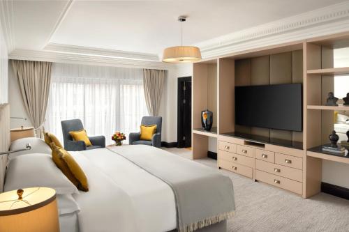 a hotel room with a large bed and a flat screen tv at Hyatt Regency London - The Churchill in London