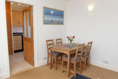 una cucina e una sala da pranzo con tavolo e sedie di Mulberry Cottage a Whithorn