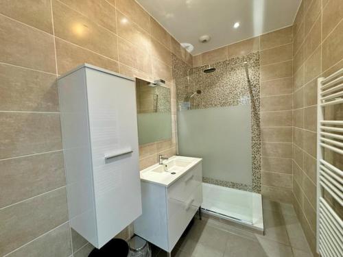 une salle de bain avec un lavabo blanc et une douche dans l'établissement Le citron, Bel appartement en pleine nature à 2 minutes du centre ville, à Hyères