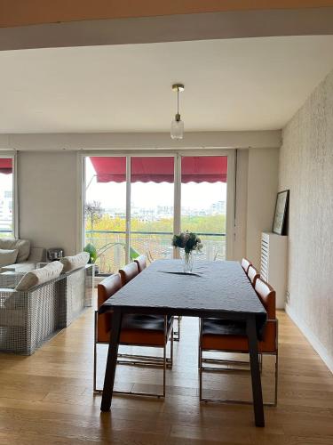 - un salon avec une table à manger et des chaises dans l'établissement Apartment with eiffel tower and Seine view Blériot, à Paris