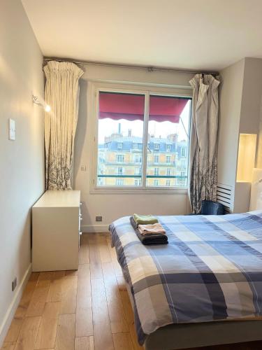 une chambre avec un lit et une fenêtre dans l'établissement Apartment with eiffel tower and Seine view Blériot, à Paris