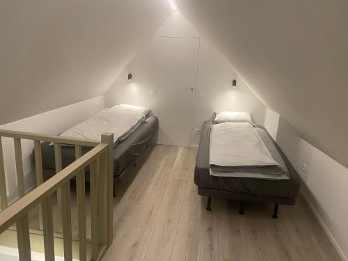 2 camas individuales en una habitación con escalera en La Forteresse, en Borgloon