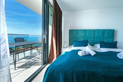 Un dormitorio con una cama y un balcón con una mesa. en Apartmani Brela 15 luxury, en Brela