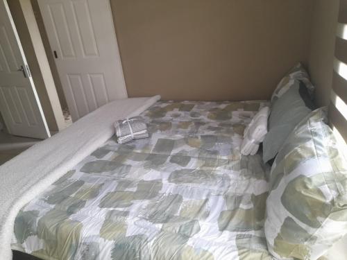 an unmade bed in a bedroom with a bedspread at Park Q Residence in Pimville