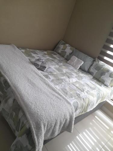 a bed sitting in a bedroom next to a window at Park Q Residence in Pimville