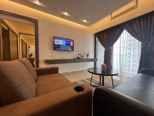 a living room with a couch and a tv at QUINCE HOME GRAND ION DELEMEN GENTING HIGHLANDs in Genting Highlands