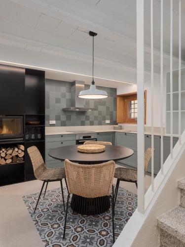a kitchen with a table and chairs in a room at Majordoms Estada Historica in Banyoles