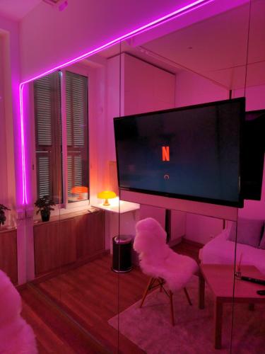 d'un salon avec une télévision et des lumières violettes. dans l'établissement Studio 10m2 Cosy sur Nice, à Nice