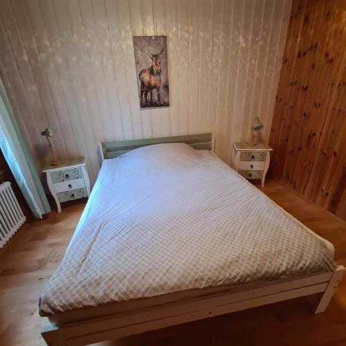 a bed in a bedroom with two nightstands and two tables at Auszeitoase am Wald und Bach in Kradolf