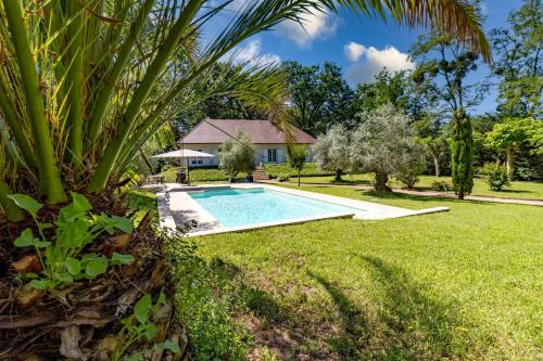 une piscine dans une cour avec un palmier dans l'établissement La Villa Cyrano - Maison avec piscine privée!, à Bergerac