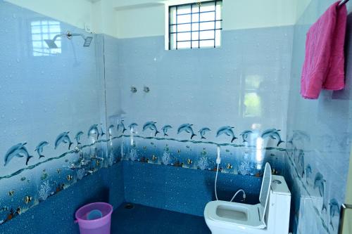 a blue bathroom with a toilet and a sink at coorg misty mountains guest house in Madikeri