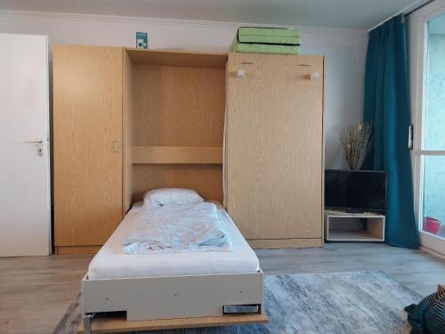a bedroom with a bed and wooden cabinets at Ferienwohnungen Adri im Ferienpark Geyersberg in Freyung