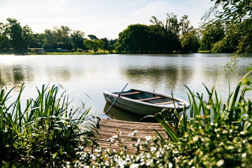 a boat sitting on the water next to a dock at Estancia La Paz Hotel in Ascochinga