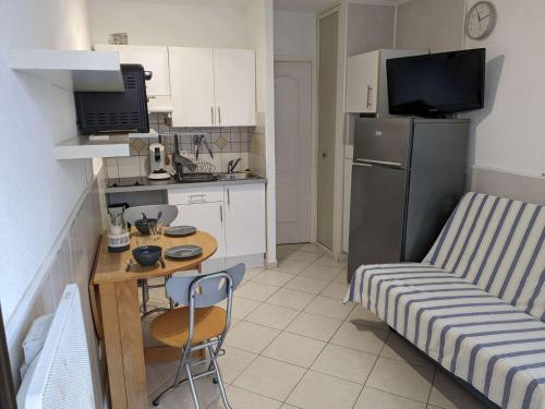 Il comprend une petite cuisine avec une petite table et un réfrigérateur. dans l'établissement Appart Studio 2 couchages PORT LEUCATE NATURISME PL010-732, à Leucate-Plage
