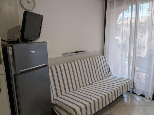 Cette chambre dispose d'un canapé et d'une télévision. dans l'établissement Appart Studio 2 couchages PORT LEUCATE NATURISME PL010-732, à Leucate-Plage
