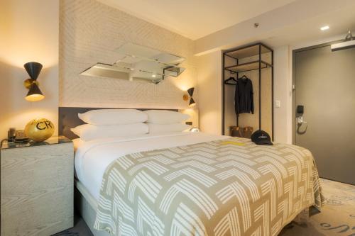 a bedroom with a large bed with white pillows at Pestana CR7 Times Square in New York