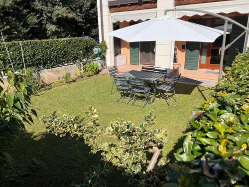 a table and chairs under an umbrella in a yard at Sweet Home Apartment in Cavaion Veronese