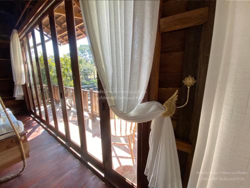 a wedding dress hanging from a window in a room at Luxury Treehouse Khaoyai in Ban Nong Makha