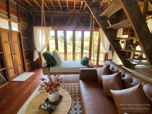 a living room with a couch and a table at Luxury Treehouse Khaoyai in Ban Nong Makha