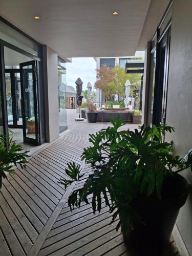 a porch with potted plants on a wooden deck at 112 Luxury Studio at The Gallery in Knysna