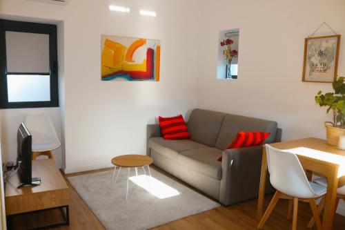 a living room with a couch and a table at 9min Metro to Downtown - couples&kids - free parking in Porto