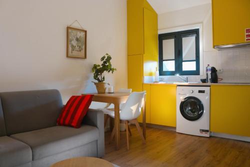 a living room with a couch and a table and a kitchen at 9min Metro to Downtown - couples&kids - free parking in Porto