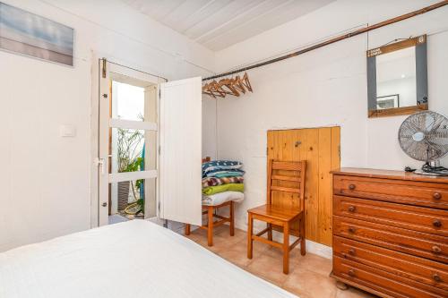 a bedroom with a bed and a dresser and a chair at Casa da Praia 2 in Budens
