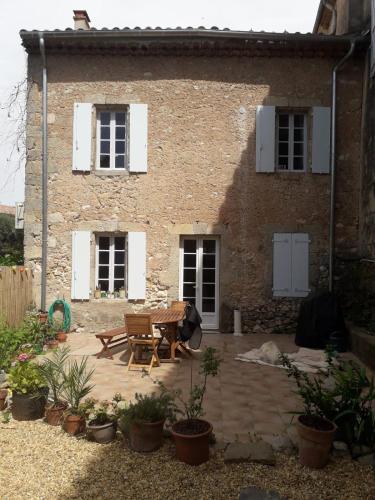 une terrasse en face d'une maison en briques dans l'établissement Maison rose, à Capestang