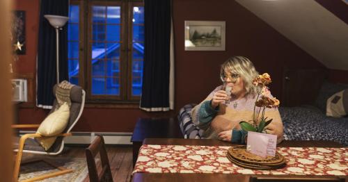 a woman sitting at a table with a microphone at Mistiso's Place Vacation Rentals in Nelson
