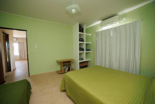 a green bedroom with a bed and a window at Hospedaje San Gabriel in General Alvear