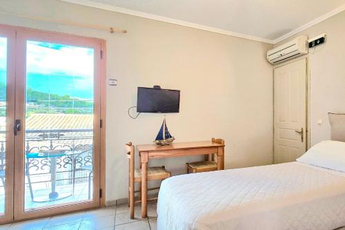 a bedroom with a bed and a desk with a television at Lefkas Apt in Gaios