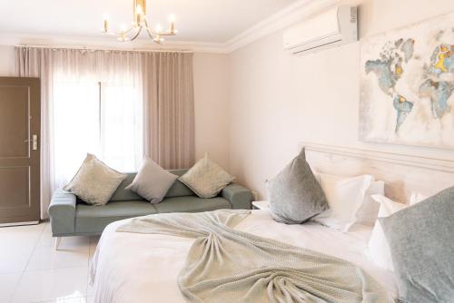 a bedroom with a bed and a couch at Prisatt Boutique Hotel in Onverwacht