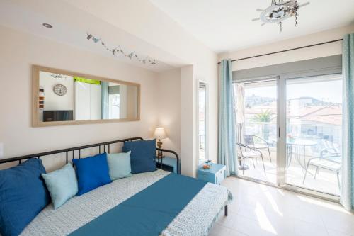 a bedroom with a blue bed and a balcony at Coco cozy home in Pefkochori