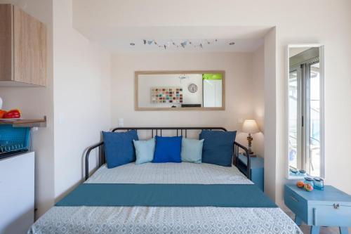 a bedroom with a bed with blue pillows at Coco cozy home in Pefkochori