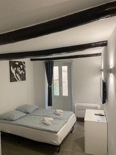 une chambre avec un lit avec deux animaux en peluche dessus dans l'établissement Renovated studio in the heart of the Old Town, à Menton