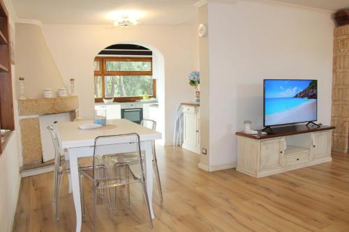 a kitchen and dining room with a table and a tv at Bellavista Vacation in Olbia