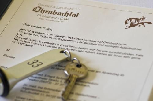 a key sitting on top of a menu at Gasthof & Landhotel Ohrnbachtal in Weilbach