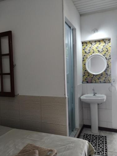 a bathroom with a sink and a mirror at Canto da Arte - Hospedagem Domiciliar in Cabo Frio