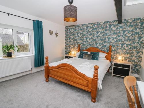 une chambre avec un lit en bois et une fenêtre dans l'établissement La Bastille, à Haverfordwest