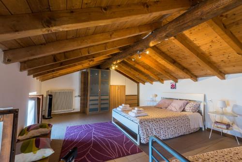una camera con letto in una stanza con soffitti in legno di Lake Como - Great View a Gravedona