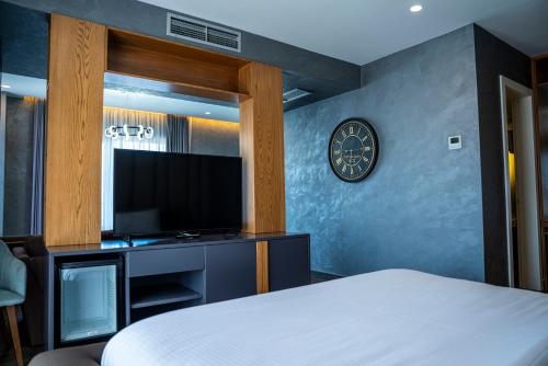 a bedroom with a bed and a flat screen tv at Henry Resort & Spa in Golem