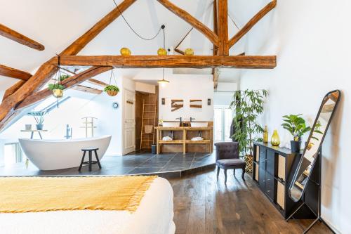 une chambre avec une baignoire et une chambre avec un lit dans l'établissement La Maison de Souhey, à Souhey