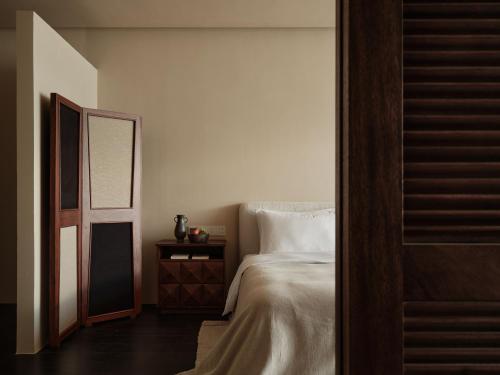 a bedroom with a white bed and a mirror at 大理空岛半山海景民宿 in Dali