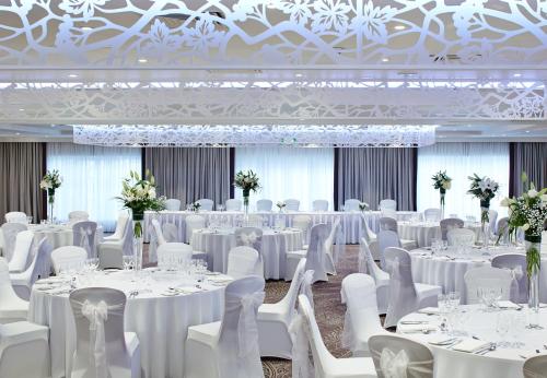 a banquet hall with white tables and white chairs at Dalmahoy Hotel & Country Club in Edinburgh