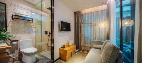a bathroom with a toilet and a glass shower at 客谈民宿Ketan Exquisite Guesthouse in Xiamen
