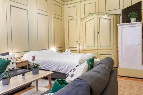 a living room with a bed and a couch at Chambre atypique dans la vieille ville de Fribourg in Fribourg