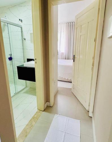 a bathroom with a shower and a sink and a mirror at kitnet dos Sonhos in Florianópolis
